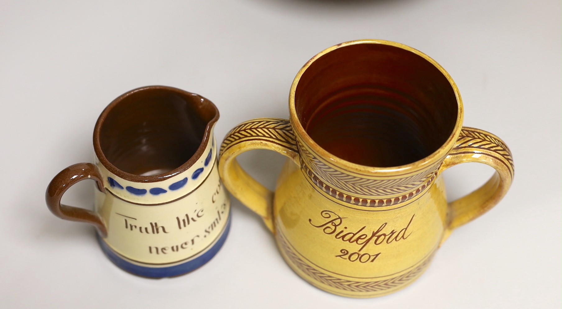 Margaret Brompton studio pottery bowl with insects, together with a slipware jug, a Longpark, Torquay small cockerel jug, and a Susan Juniper slipware jug, largest 21cm diameter, (4)